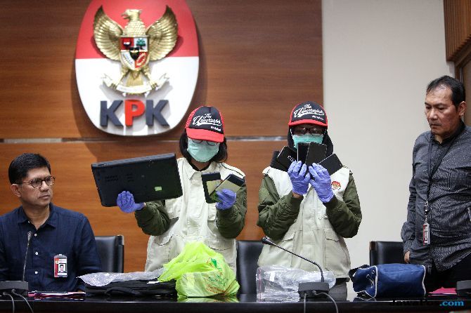 Dua petugas KPK didampingi Wakil Ketua Laode M Syarif (kiri) dan Saut Situmorang (kanan) saat menunjukkan barang bukti atas OTT di Lapas Sukamiskin, Bandung. - Image