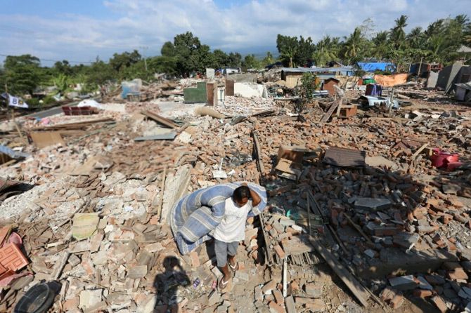 Warga Lombok mengevakuasi barang-barang miliknya yang masih bisa diselamatkan. - Image