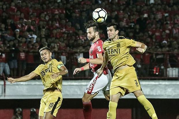Striker Bali United, Ilija Spasojevic (merah) saat memperebutkan bola di udara melawan Vladimir Vujovic dan Jajang Mulyana. - Image