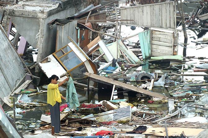 Salah seorang warga mengais sisa-sisa baju dari lokasi likuifaksi Balaroa, Palu, Sulawesi Tengah, Minggu (9/12). Hampir memasuki dua bulan lebih pascabencana Sulteng, warga masih mendatangi lokasi ini untuk mencari barang yang masih bisa digunakan. - Image