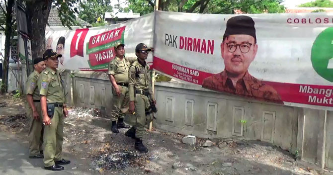 PENERTIBAN APK: Sejumlah petugas dari Satpol PP dan Linmas tengah melakukan penertiban APK Pilgub, Senin (25/6). - Image