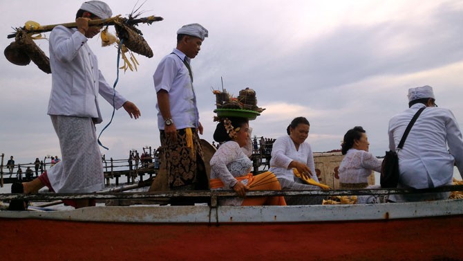 SESEMBAHAN: Sejumlah umat hindu membawakan sejumlah sesajian untuk prosesi upacara. Diantaranya, buah-buahan, padi, dan ternak sewaktu prosesi Upacara Melasti di Pantai Akkarena Makassar, Minggu (11/3). - Image