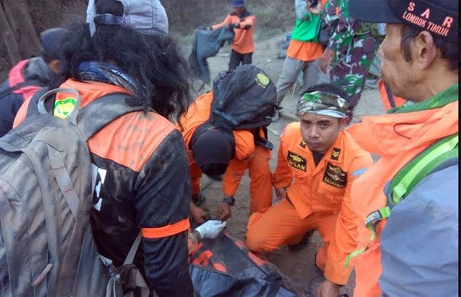 EVAKUASI: Tim evakuasi gabungan saat memasukan jenazah salah satu pendaki asal Makassar, Muhammad Ainul Muksin yang meninggal di Gunung Rinjani pascagempa ke kantong mayat. - Image
