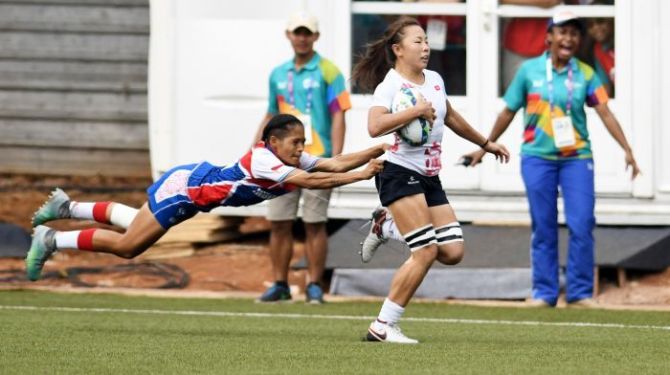 Pemain rugby Indonesia, Fanny Givllia Garasati (kiri) menahan laju pemain Hong Kong Nam Ka Man saat berlari dipertandingan babak peringkat 5-8 Rugby 7 Putri Asian Games Ke 18 di Lapangan Rugby 7s, Gelora Bung Karno, Jakarta, Sabtu (1/9). - Image