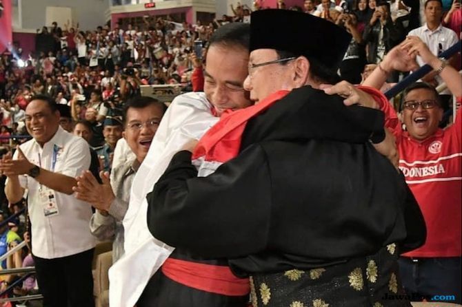 Dua calon presiden yang bakal bertarung di Pilpres 2019, Joko Widodo dan Prabowo Subianto saling berpelukan ketika menyaksikan cabor Pencak Silat Asian Games 2018. Jawa Barat bakal menjadi medan pertempuran yang sengit buat keduanya - Image