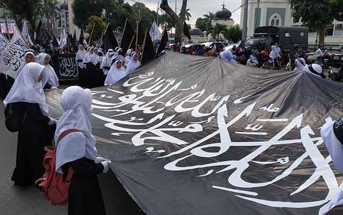 Massa mengarak dua bendera tauhid dalam aksi menuntut pembubaran Banser NU di Kota Medan, Kamis (25/10). - Image