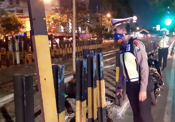 KECELAKAAN MAUT: Unit Laka Lantas Polrestabes Surabaya tengah meninjau dan akhirnya mengevakuasi korban dari lokasi kejadian. - Image