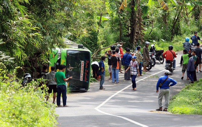 Bus memuat rombongan murid SDN Margobenr, Kecamatan Tarik, Kabupaten Sidoarjo yang terguling di jalan tanjakan Desa Sukolilo, Kecamatan Prigen, Kabupaten Pasuruan, Sabtu (17/3) pagi. - Image