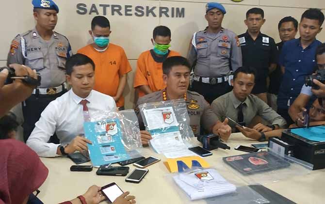 abid Humas Polda Sulsel Kombes Dicky Sondani (tengah) didampingi Kasatreskrim Polrestabes Makassar Kompol Wirdhanto Hadicaksono (kiri) dalam rilis ungkap kasus perjokian CPNS, Kamis (8/11). - Image