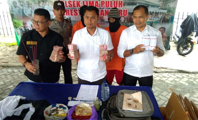 DUKUN PALSU: Kanit Reskrim Polsek Limapuluh Iptu Abdul Halim (tengah) ekspos pengungkapan kasus 2 dukun palsu di Mapolsek Limapuluh, Senin (3/12) siang. - Image