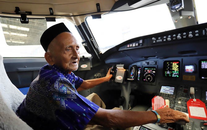 Nyak Sandang menjajal kursi pilot di Kokpit Pesawat CRJ 1000 Bombardier di area Hanggar Pesawat Garuda Indonesia di GMF AeroAsia Bandara Soekarno Hatta Tangerang, Banten, Kamis (5/4). - Image