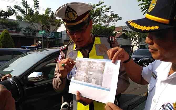 Petugas menunjukkan bukti screenshoot CCTV yang merekam pelanggaran lalu lintas para pengguna jalan, Kamis (2/8). - Image