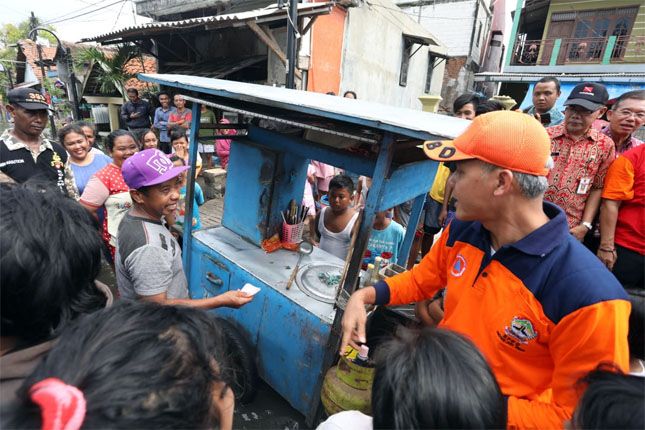 SIDAK BANJIR: Gubernur Jateng Ganjar Pranowo mentraktir mi ayam warga terdampak banjir di Kampung Purwosari, Semarang, Selasa (4/12). - Image