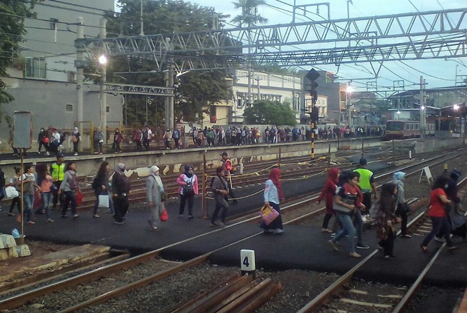 Penumpang KRL tujuan Tangerang menyeberang manual melalui jalur crossing menuju peron 5 perlintasan Duri-Tangerang PP. - Image