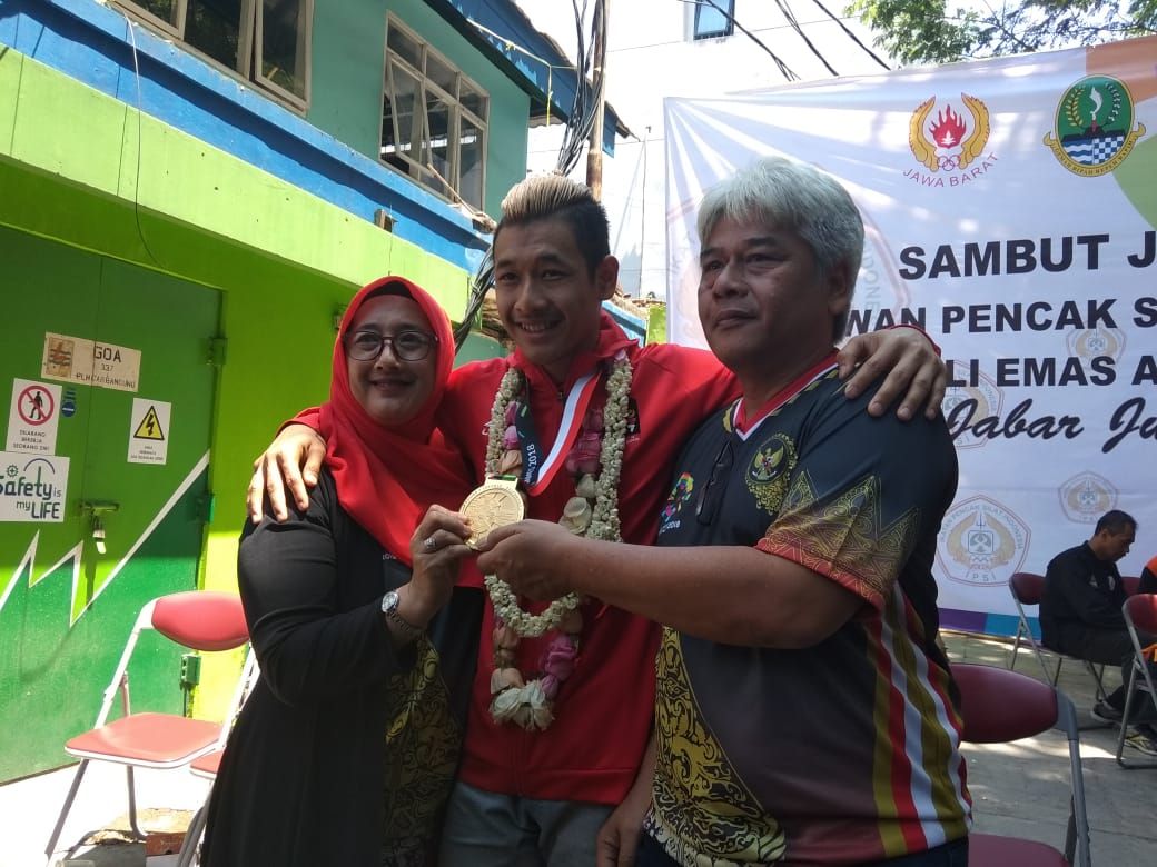 Pesilat Jawa Barat, Hanifan Yudani Kusumah bersama kedua orang tuanya di GOR Padjadjaran Bandung, Senin (3/9). - Image