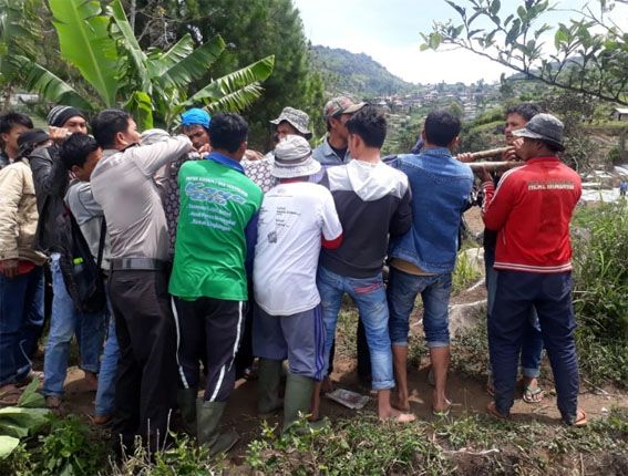Petugas Mapolsek Danau Kembar bersama warga mengevakuasi korban tenggelam di danau Bawah, Kabupaten Solok. - Image