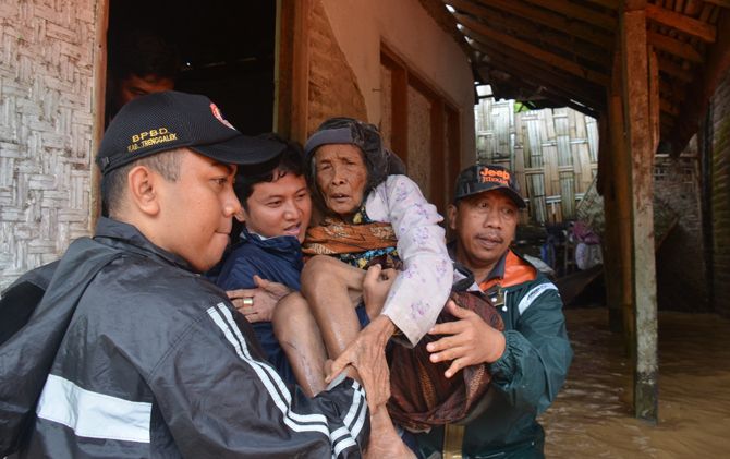 Plt Bupati Trenggalek M. Nur Arifin saat menggendong Mbah Sainah menuju perahu. - Image