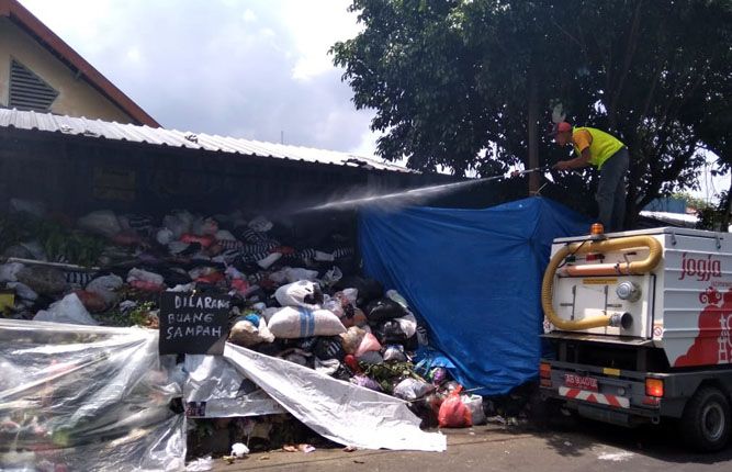 MENUMPUK: Seorang petugas tengah menyemprotkan disinfektan di TPS dekat Taman Kanak-kanak (TK) Grha Asih Anak Gayam, Baciro, Kecamatan Gondokusuman, Kota Jogjakarta, Rabu (27/3). - Image