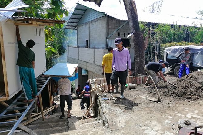 Para santri bergotong royong membangun rumah untuk tempat tinggal mereka selama mondok. - Image