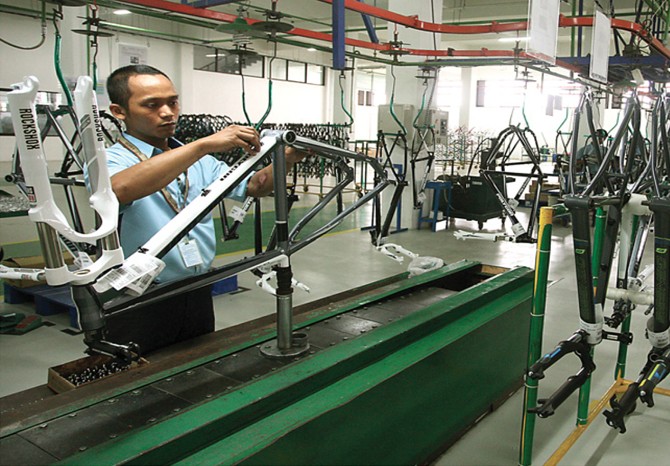 Pekerja merakit sepeda Polygon di pabriknya di kawasan Sidoarjo. Sejauh ini Polygon masih menjadi market leader di pasar tanah air. (Dite Surendra/Jawa Pos) - Image