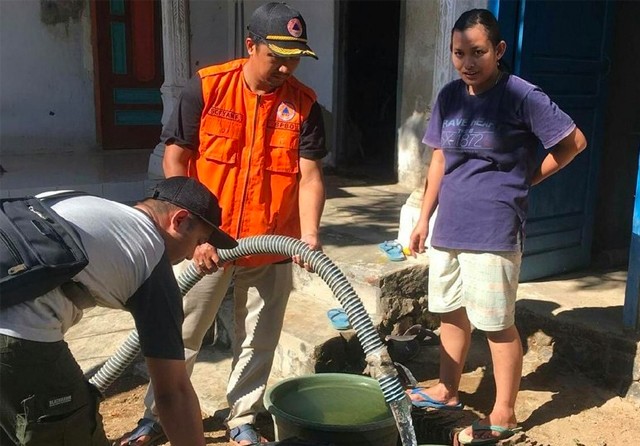MEMANG BUTUH: Petugas BPBD Trenggalek mendistribusikan bantuan air bersih di wilayah Kecamatan Panggul. (BPBD for Radar Trenggsalek) - Image