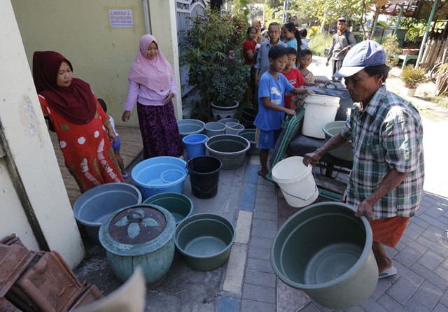 Warga Sememi Jaya gang Gajah ketika mengantri dengan ember untuk menunggu truk air dari PDAM, Jumat (12/7). (Guslan Gumilang/Jawa Pos) - Image