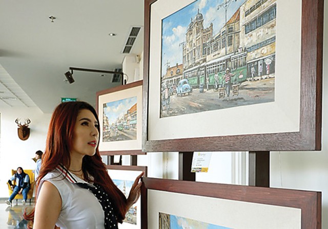 TERPESONA: Felicia Tansatrisna mengamati karya lukisan Fauzi yang dipamerkan hingga akhir Agustus. (Mariyama Dina/Jawa Pos) - Image