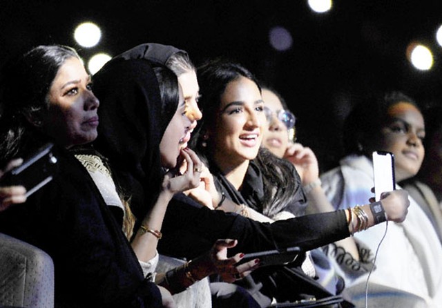 MAKIN BANYAK HIBURAN: Perempuan Arab Saudi sibuk berswafoto dalam konser penyanyi opo asal Mesir Tamer Hosny di Jeddah 30 Maret 2018. (AMER HILABI/AFP) - Image