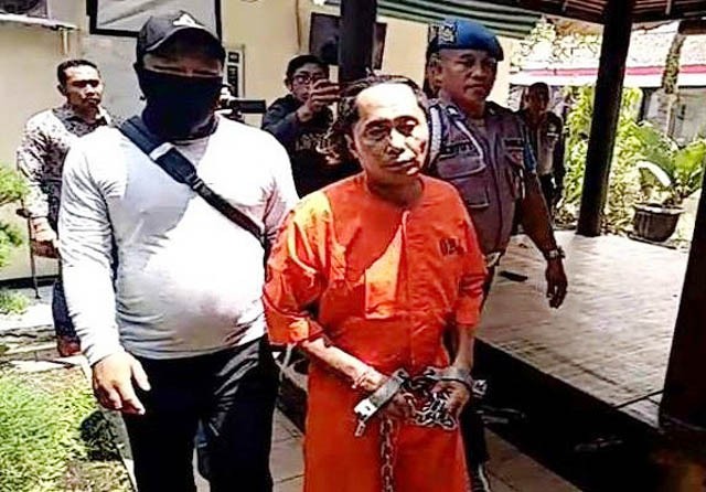 Tersangka Ketut Umbu Sugriwa digiring penyidik dengan tangan dan kaki dirantai di Polsek Sukawati, Kamis siang (Indra Prasetia/Jawa Pos Radar Bali) - Image