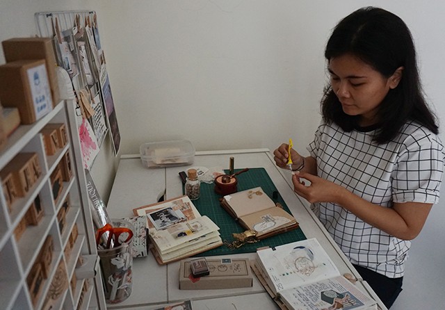 BANYAK ELEMENNYA: Gevita Chrismadwi dan perlengkapan yang dia gunakan untuk creative jour naling. (Kartika Sari/Jawa Pos) - Image