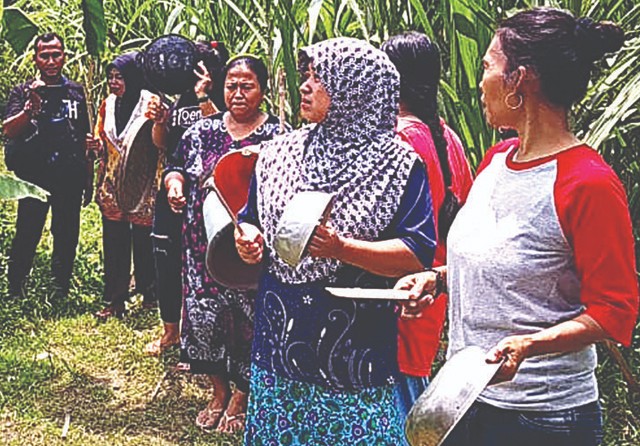 BERHARAP DITEMUKAN: Sejumlah warga menabuh peralatan dapur untuk mencari seseorang yang hilang di Desa Beratkulon, Kecamatan Kemlagi, Kabupaten Mojokerto. (Rizal Amrulloh/Jawa Pos Radar Mojokerto) - Image