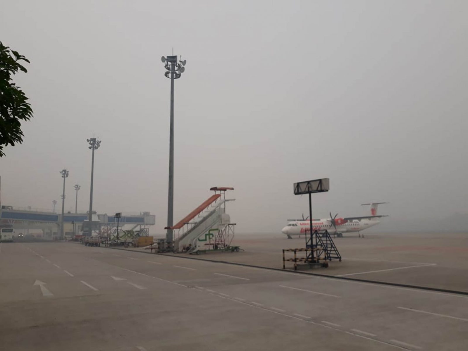 Kondisi bandara Sultan Syarif Kasim II diliputi asap saat pagi, beberapa penerbangan ditunda karena buruknya cuaca, Jumat (13/9). (Said Mufti/Riau Pos) - Image
