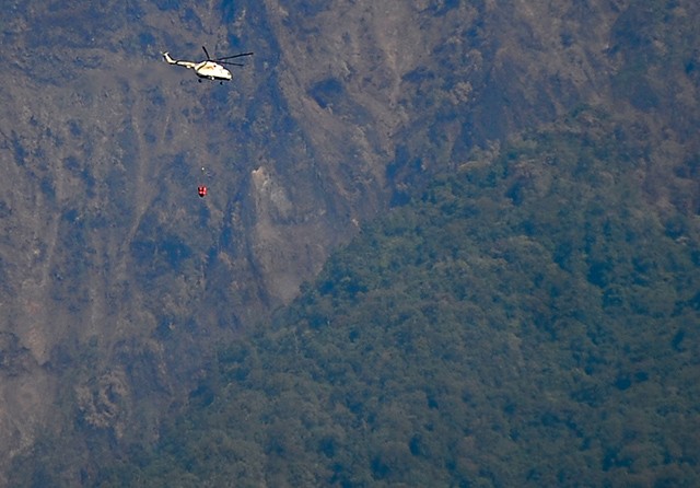 Sehari 14 Kali: Heli yang dipiloti Captain Lhor Didukh dari Rusia mengangkut air menuju titik kebakaran. (Ramada Kusuma/Jawa Pos Radar Banyuwangi) - Image