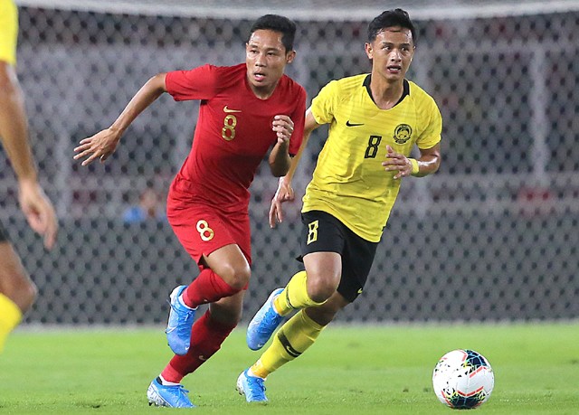 Evan Dimas berusaha melewati Nor Azam (kanan) ALberto Goncalves merayakan gol pertamanya mealawn malaysia, pada laga kualifikasi piala dunia 2022 di sugbk, kamis 5/9/19. Indonesia kalah 2-3. Foto: Chandra Satwika/Jawa Pos. - Image