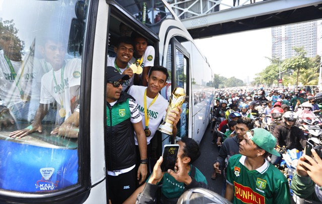 Rizky Ridho membawa piala juara Liga 1 U-20 disambut oleh ribuan Bonek di Jl. Frontage Ahmad Yani, kemarin (13/10). FOTO: Angger Bondan/Jawa Pos - Image