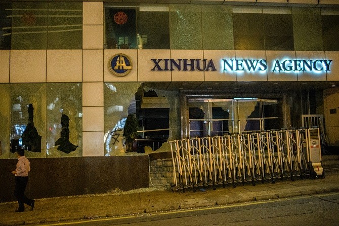 A pedestrian walks past China - Image