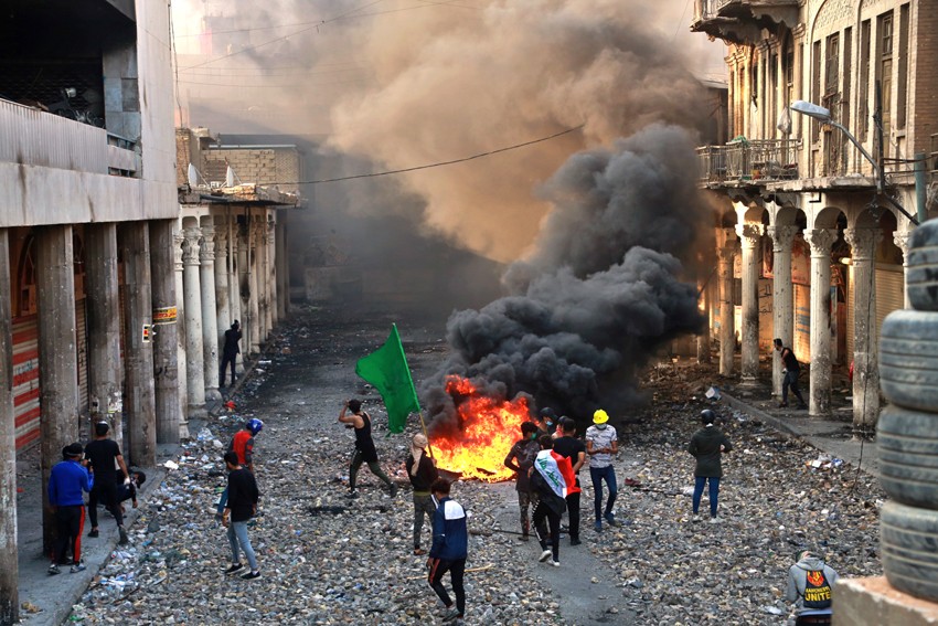 Anti-government protesters set fire while security forces close Rasheed Street during clashes in Baghdad, Iraq, Thursday, Nov. 28, 2019. Scores of protesters have been shot dead in the last 24 hours, amid spiraling violence in Baghdad and southern Iraq, o - Image