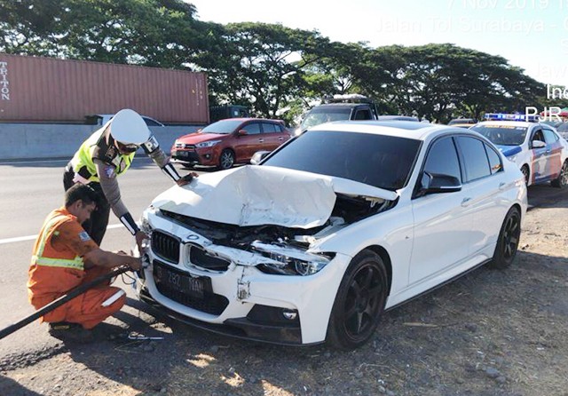 Polisi memeriksa moncong BMW yang menabrak pikal di tol Surabaya-Sidoarjo. (PJR Tol II Polda Jatim for Jawa Pos) - Image