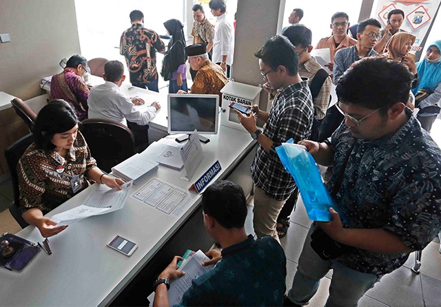 TINGGAL CETAK: Pemohon SKCK di Polrestabes Surabaya. (Guslan Gumilang/Jawa Pos) - Image