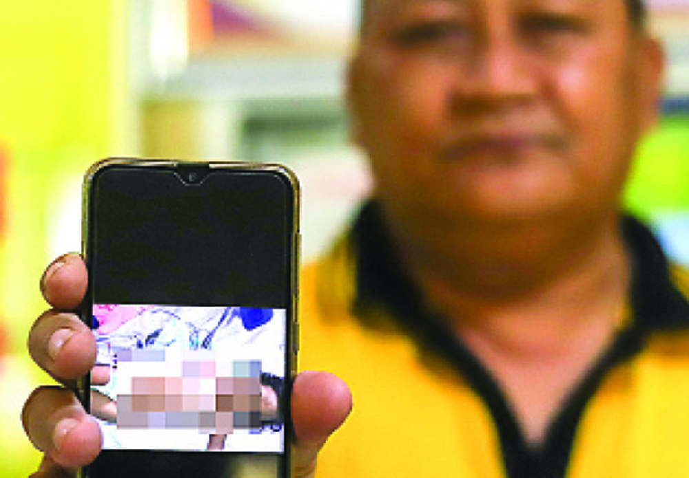 BAHAN PENGHUSUTAN: Wakapolsek Gubeng AKP Yahudi menunjukkan foto JA yang penuh luka lebam. (Alex Qomarulla/Jawa Pos) - Image