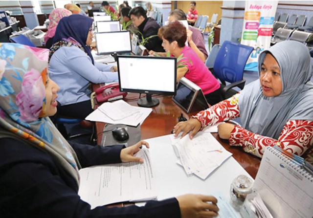 KONSULTASI: Pelanggan menunjukkan bukti-bukti dokumen kepada petugas loket PDAM. (Dite Surendra/Jawa Pos) - Image