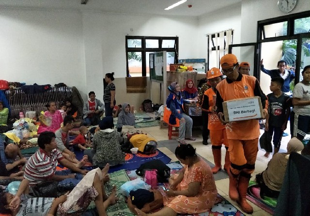 Korban banjir di Jakarta menerima paket bantuan yang disalurkan PT Bank Negara Indonesia (Persero) Tbk di Jakarta, Rabu (1/1). (BNI for JawaPos.com) - Image