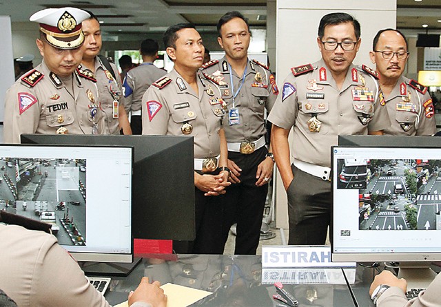 TINJAU KESIAPAN: Kakorlantas Polri Irjen Pol Istiono (tiga dari kanan) bersama Kombespol Budi Indra (tiga dari kiri) mengamati penerapan electronic traffic law enforcement (e-TLE) di Siola kemarin (16/1). (Guslan Gumilang/Jawa Pos) - Image
