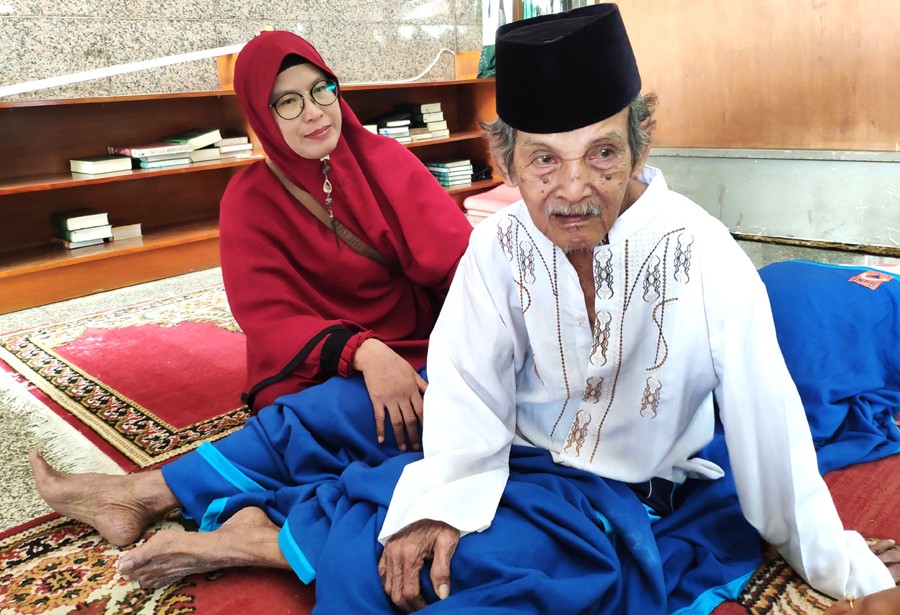 KEHILANGAN ISTRI: Muhammad Ali ditemani menantunya di pengungsian korban banjir di Universitas Borobudur, Jakarta Timur, kemarin (2/1). (ZALZILTUL HIKMIA/JAWA POS) - Image