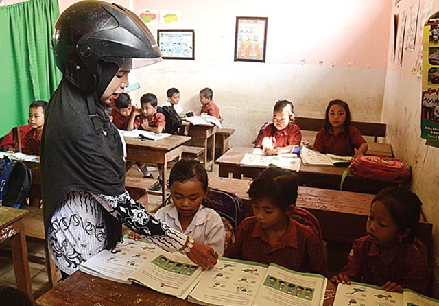 WASWAS: Uswatun, guru kelas I SDN Selodakon 03, Tanggul, Kabupaten Jember, saat mengajar siswanya kemarin. (Jumai/Jawa Pos Radar Jember) - Image
