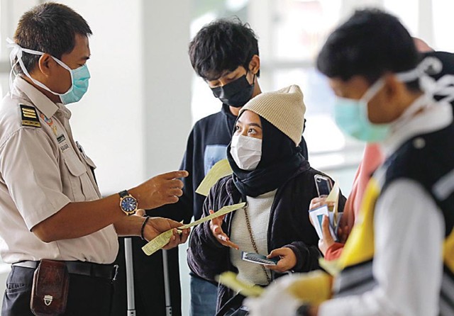 DIPERIKSA: Penumpang pesawat terbang menjalani pemeriksaan suhu tubuh oleh Kantor Kesehatan Pelabuhan (KKP) Kelas I Surabaya di Bandara Juanda, Kamis (30/1). (Dipta Wahyu/Jawa Pos) - Image