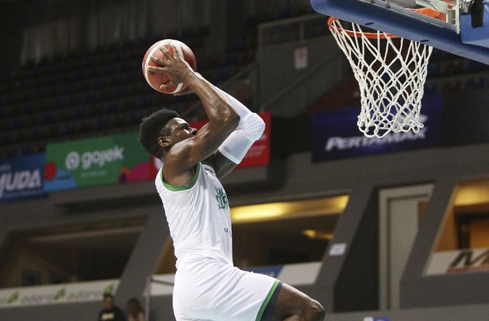 Pemain Louvre Surabaya (LVR) Michael Ayodele Kolawole melompat sebelum melakukan slam dunk saat melawan tim Satya Wacana Salatiga (SWS) pada pertandingan IBL 2020 di Mahaka Square, Jakarta, Sabtu (1/2).Louvre Surabaya (LVR) menang melawan Satya Wacana Sa - Image