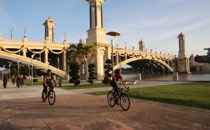 MENIKMATI SENJA: Rombongan pesepeda melintasi waterfront di Putrajaya, Malaysia. Biasanya mereka berasal dari luar kota. (Siti Aisyah/JAWA POS) - Image