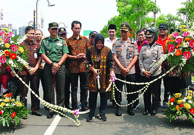 BERSAMA FORKOPIMDA: Wali Kota Tri Rismaharini (tengah) menggunting rangkaian bunga sebagai tanda peresmian penggunaan MERR II-C Gunung Anyar kemarin. (Robertus Risky/Jawa Pos) - Image