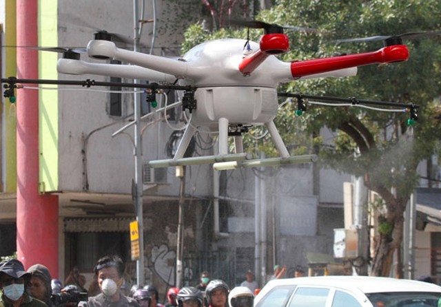 BUNUH VIRUS: Sebuah drone yang dioperasikan Pemkot Surabaya beraksi menyemprot disinfektan di kawasan Embong Malang, Senin (23/3). (Frizal/Jawa Pos) - Image